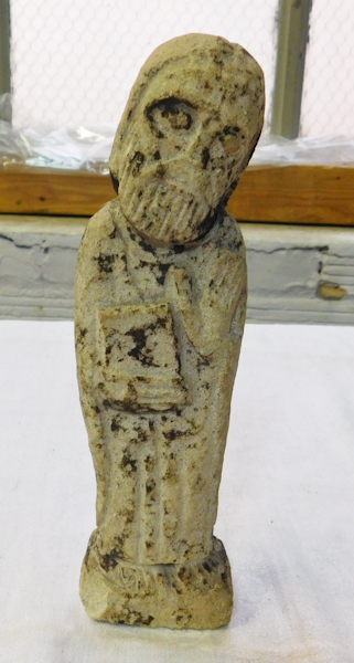 carved stone bearded irish monk holding book