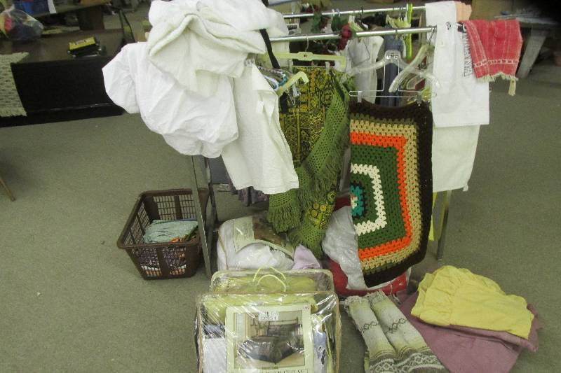 Lot of linens and quilts on a metal...