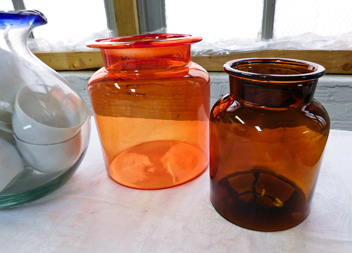 Large clear pitcher with blue rim handle two glass orange containers