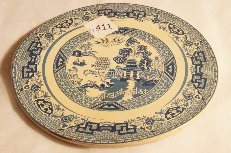 lot 411 image: Blue Willow Metal Trivet. Approx. 7 W. Nesco Metal Bestos