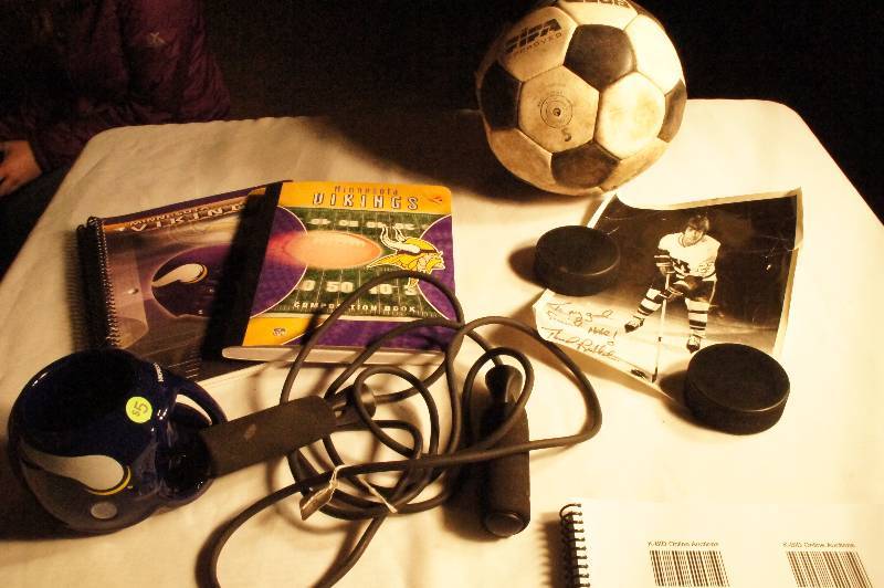 lot 435 image: Soccer Ball, MN Vikings themed notebook, jump rope, Viking Mug, hockey puck