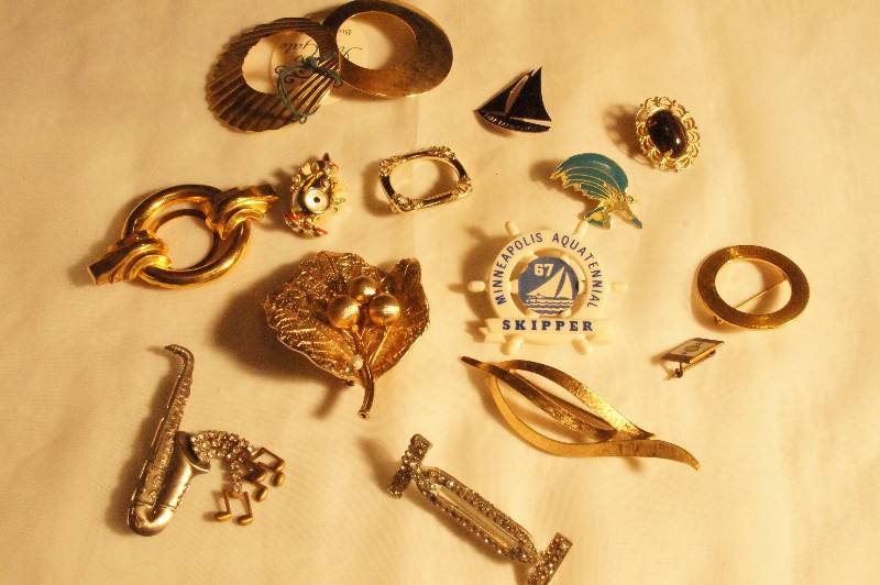 lot 505 image: Lot of Pins - including Minneapolis Aquatennial Skipper 67, Scarf Clips, Vintage pins, Batman, Golf Leaf, Clown Park Rapids Sailboat, Saxophone, Monet Leaf Pin, ETC