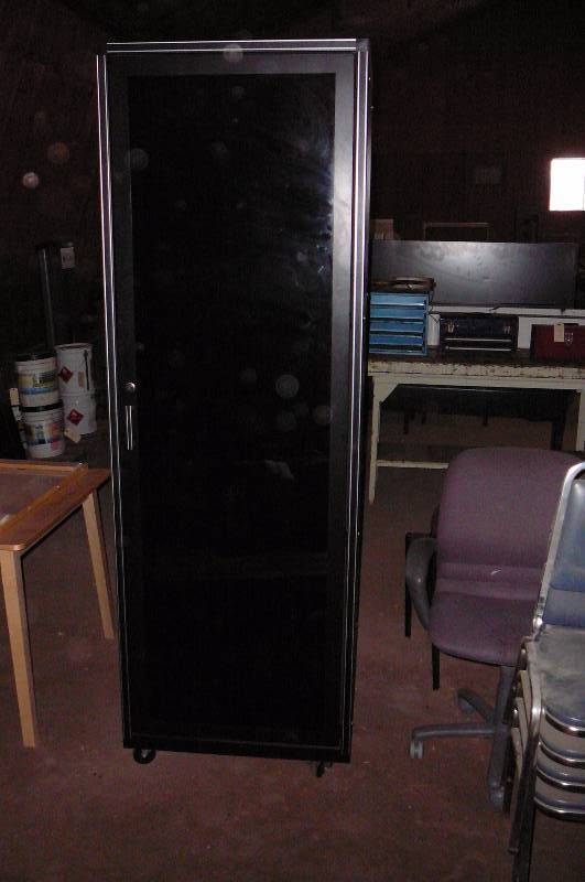 lot 110 image: Steel Cabinet with doors on 2 sides 29 x 32 x 97 12 tall on casters one side has black glass door
