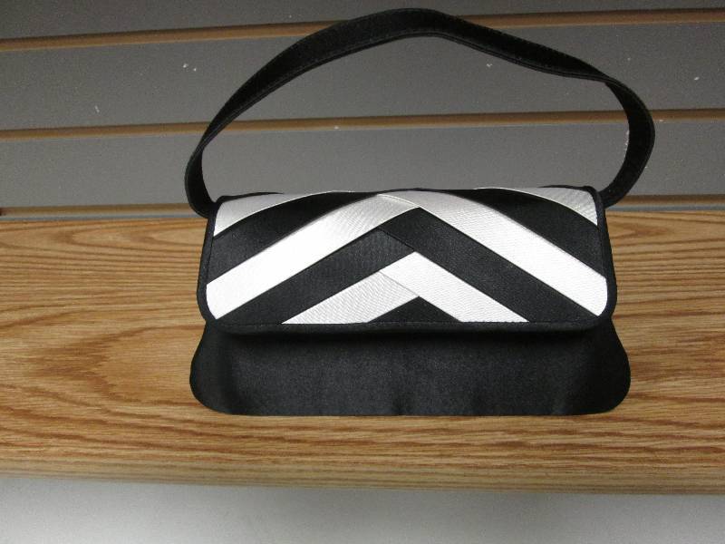 Black purse with white accent, magn...