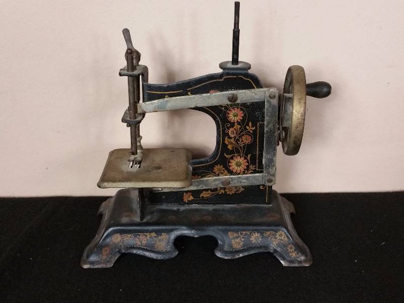 lot 25 image: Antique Salesman Sample or Childs Tin Sewing Machine