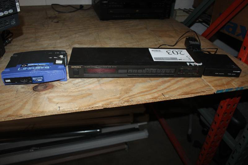 lot 203 image: Lot of (3) Electronic Equipment Including Linksys CableDSL Router With 4 Port Switch Technics AMFM Stereo Tuner Mitsubishi 3D Box