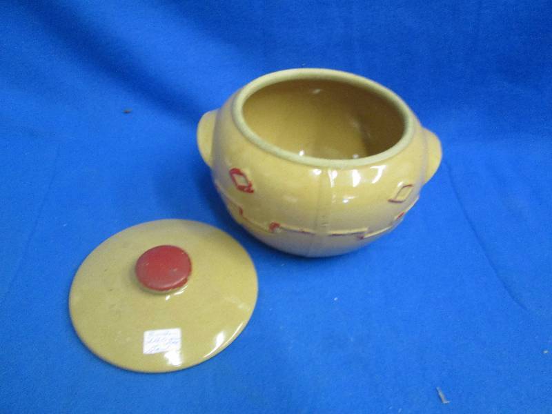 red and tan colored pot with top an...