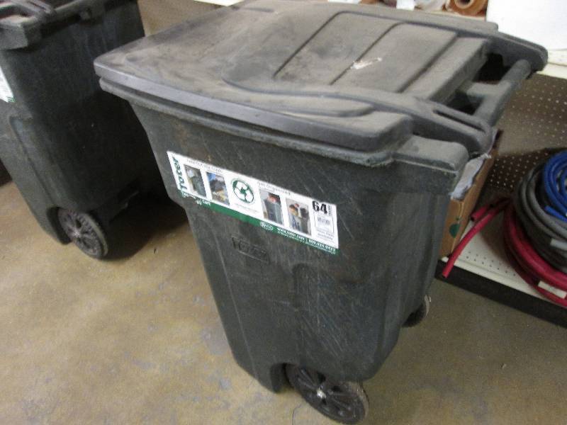 64 gallon black garbage bin on whee...