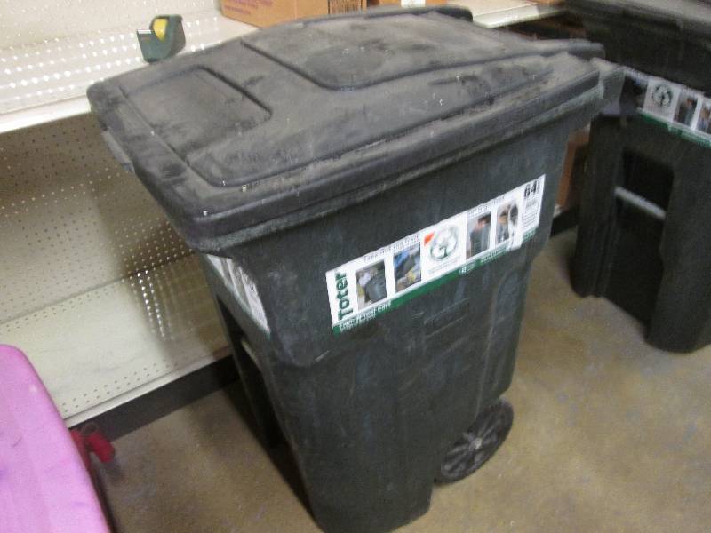 64 gallon black garbage bin on whee...