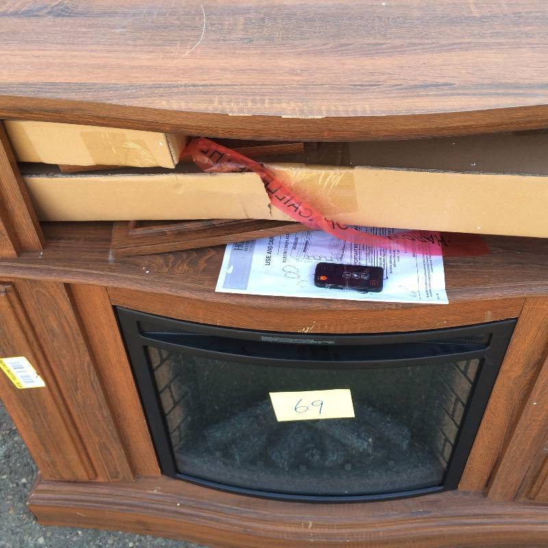 lot 69 image: Convertible Electric Fireplace in Oak with Faux Stone Surround- display model some scratches present- insert is new