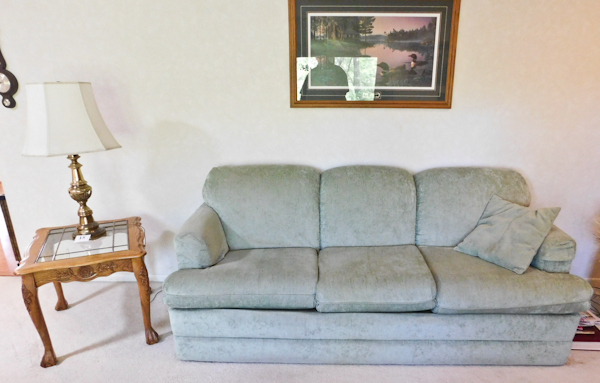 lot 15 image: Nice clean sofa, oak table glass top, lamp, framed wall art