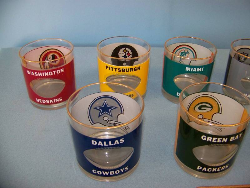 lot 16 image: (8) NFL Football, Lowball Glasses and (10) NFL Leather Coasters