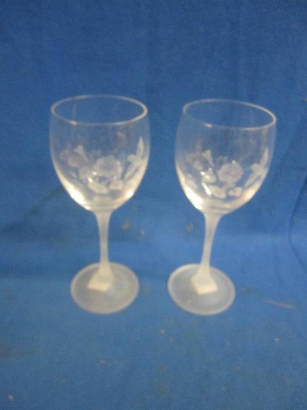 2 clear glass wine glasses with flo...