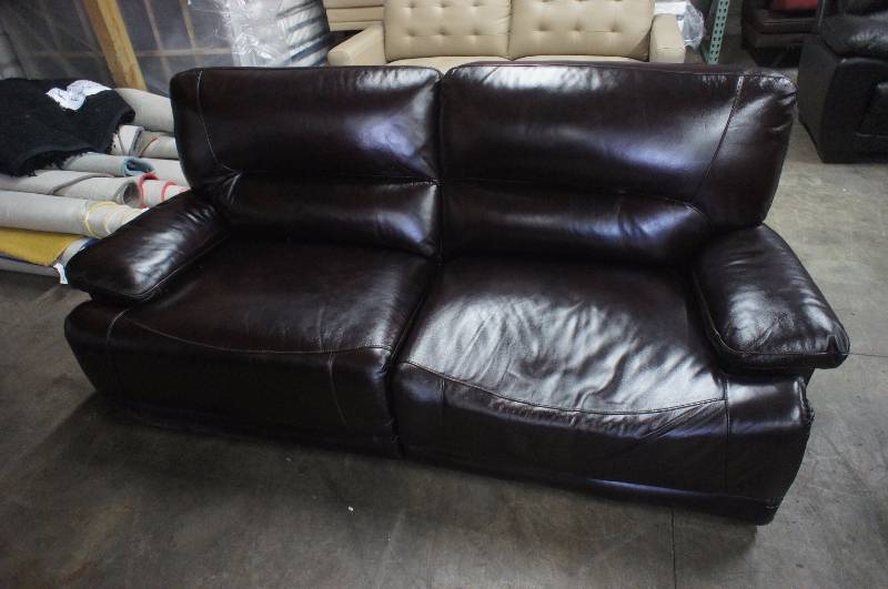 lot 15 image: 75 High End Brown Leather Power Reclining Sofa, some damage to right cushion and no power supply.