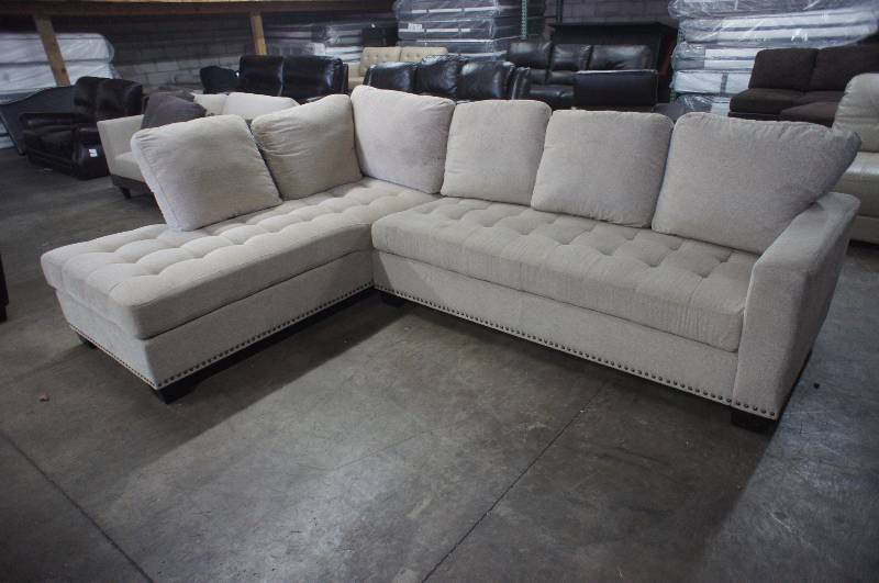lot 23 image: 115 High End Beige Fabric Sectional. Dimensions 115W X 84D X 32T