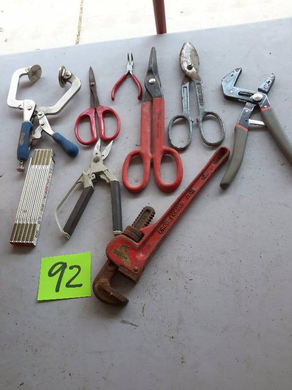 lot 92 image: Misc. Tools as pictured. 2 Tin snips, adjustable jaw wrench, KREG hand clamp.. Pipe wrench