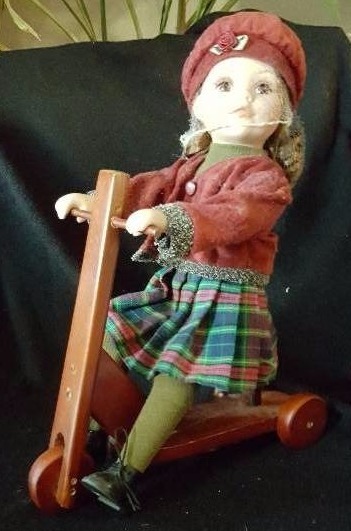 Maroon scooter porcelain doll