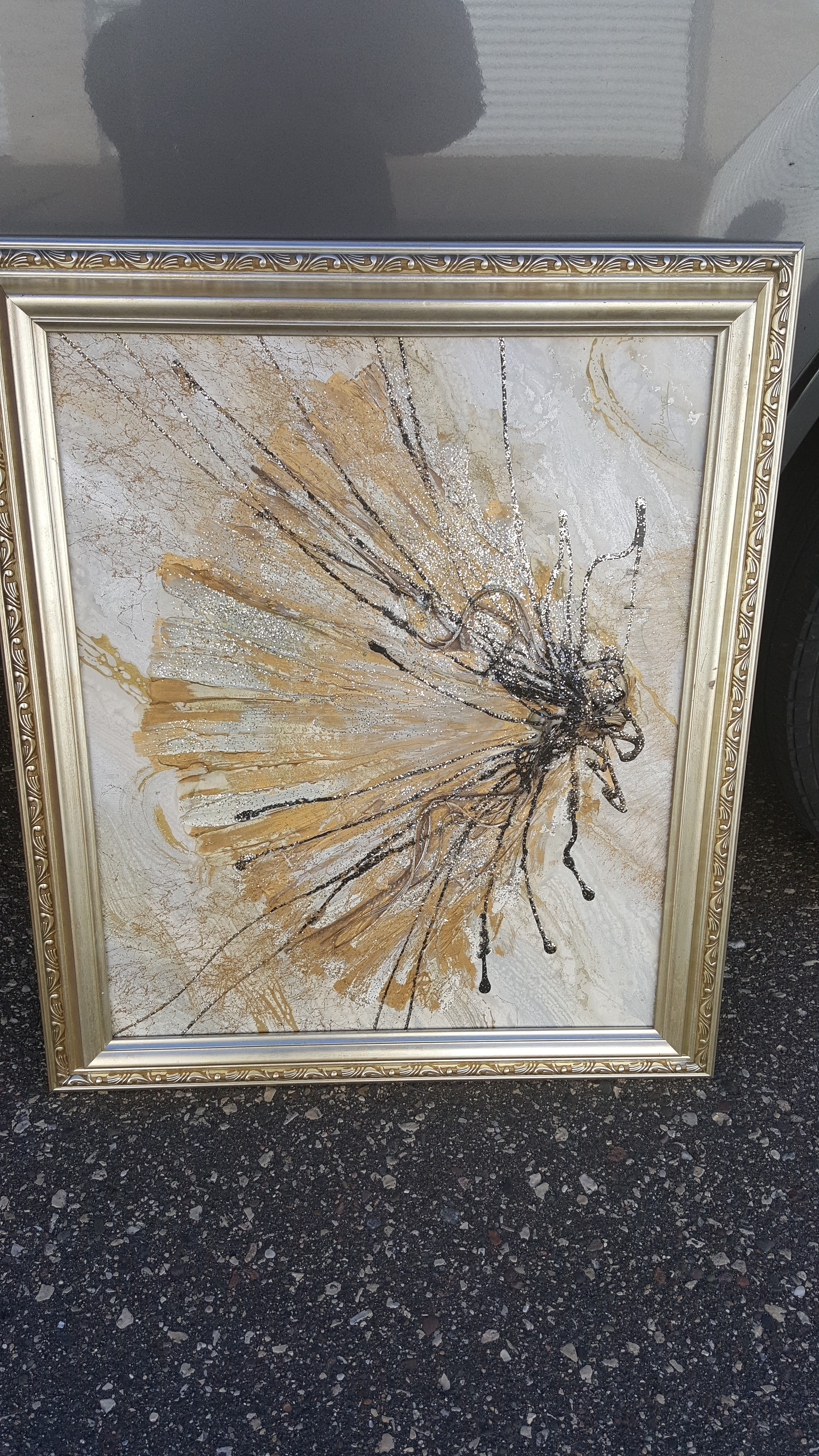 Gold colored framed abstract design.