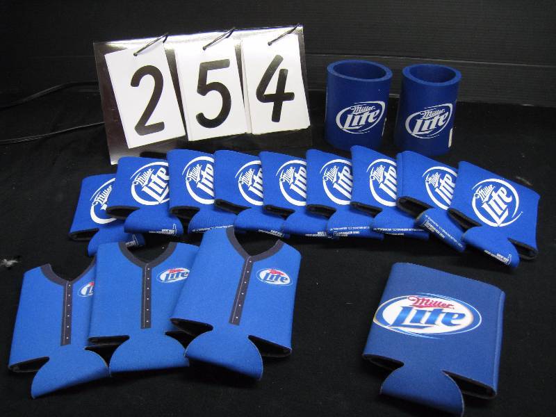 lot 254 image: Box of Miller Lite coozies, 9 neoprene with blue and white logo, 2 cup shaped, 3 baseball jerseys and 1 Miller Lite color logo with WeFest 2011 on reverse