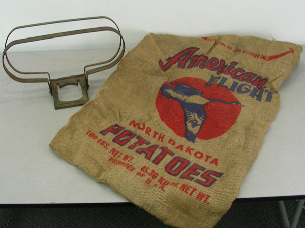 lot 16 image: Antique Ace Cast Iron Feed Sack Wall Holder & Potato Sack