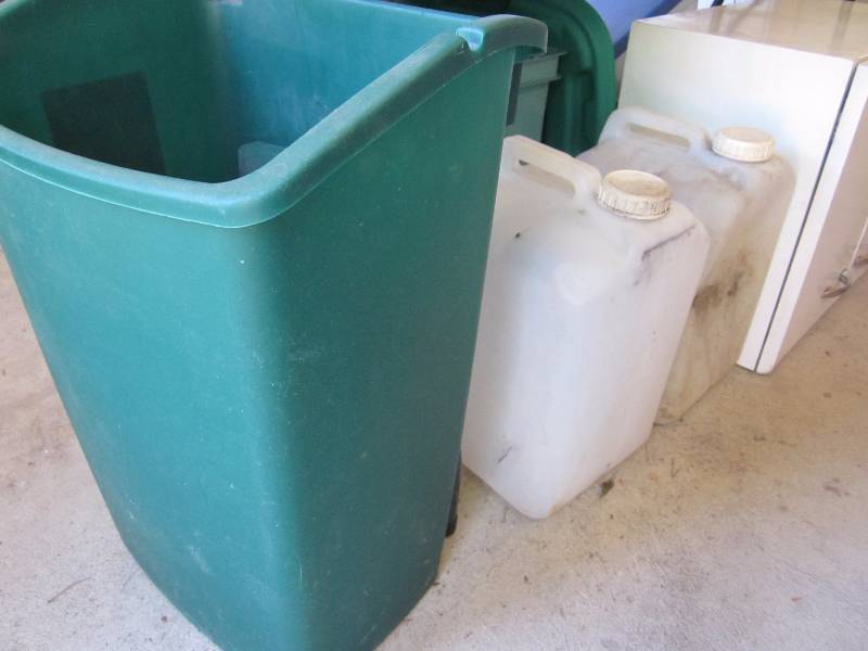 Metal Cupboard, 2 Water Jugs, and Green Garbage Can