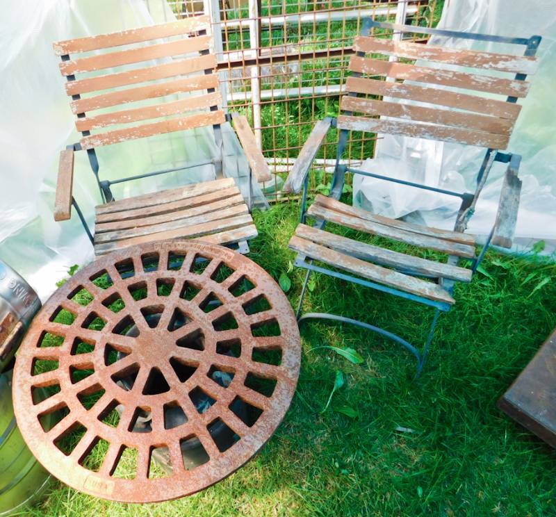 lot 97 image: rustic drain cover milk can table and two metal and wood chairs