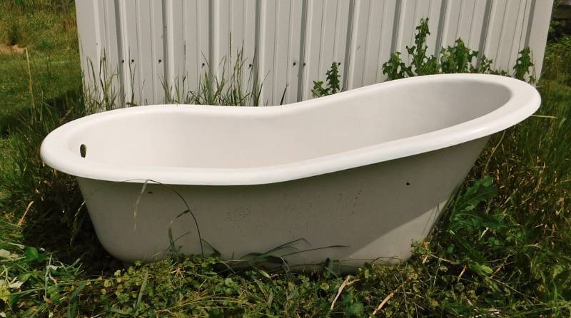 lot 1 image: Porcelain on cast iron tub with solid brass feet and plumbing