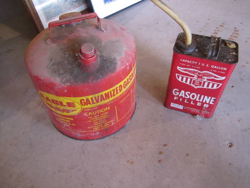 lot 52 image: gas cans, one has a couple gallons ...