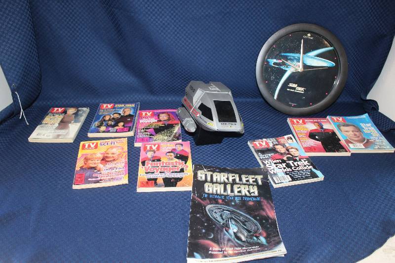 lot 320 image: Star Trek Memorabilia Including Centric The Next Generation USS Enterprise Wall Clock, Magellan Toy, Starlet Gallery Book, Multiple TV Guides