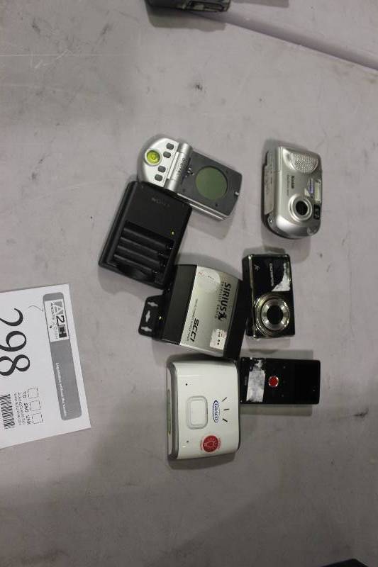 lot 298 image: Lot of (7) Electronics Including 1) Graco Nightlight AND 1) Digital Compass AND 1) Sirius Satellite Radio SCC1 Tuner AND 1) Cisco Camera AND 1) Flip Video Camera AND 1) Olympus fe Digital Camera AND 1) Kodak EasyShare CX6200 Digital Camera