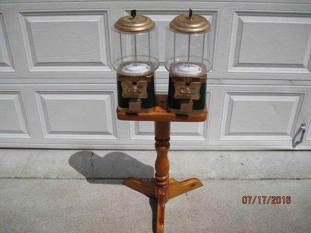lot 11 image: Vintage Double Headed Candy Dispenser with Stand that uses Quarters.