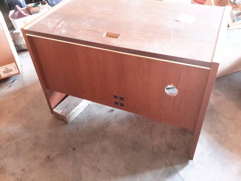 lot 81 image: Simulated wood desk.  50in w x 30 in d x 31 in h.  Shelf and hole for cords.  Solid