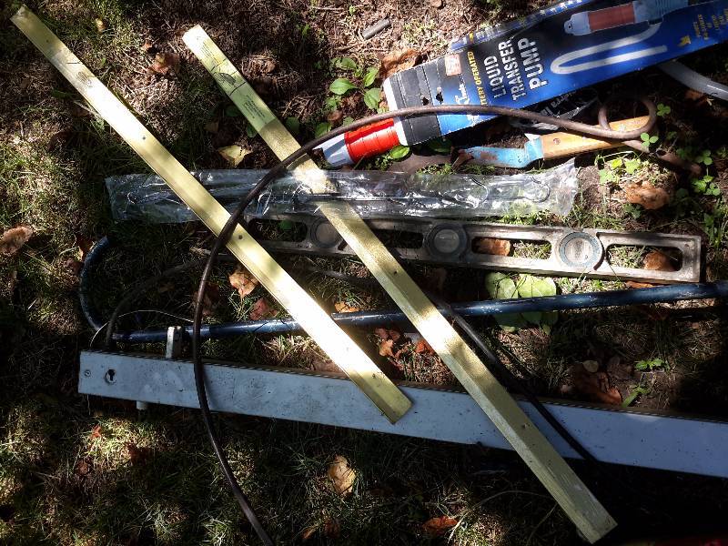 lot 28 image: Misc. items from the shed.. Fluorescent fixture, 2 Gas Cans, level, hay rack tooth, 2 thresholds.  Other items as pictured