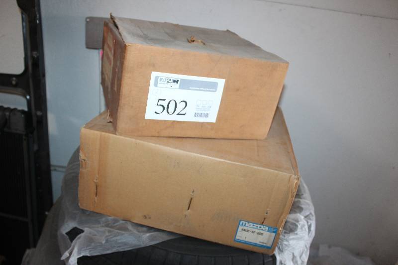 lot 502 image: Lot of (2) Boxes of Automotive Parts Including 1) Remanufactured Flow Tested Carburetor w Governor 7R7158 F Trk 381 c. AND 1) Mazda 14x5.5 Wheel Part 8AU2-37-600