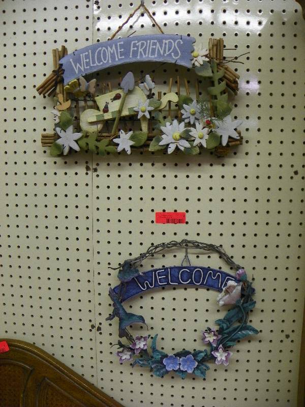 Welcome signs, one wood with flowers and ladybugs, one metal with flowers and hummingbird