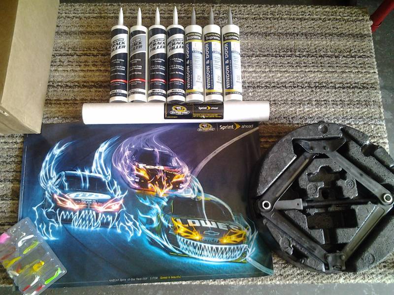 lot 79 image: 4-Black Top Crack Fillers, 3-Window & Door Caulks, Jack, Package Of Lures, Nascar Poster