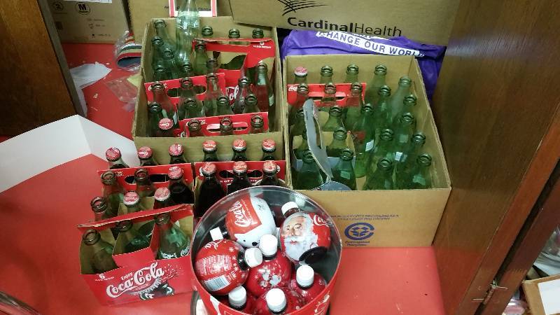 lot 91 image: Large Lot of Coca-Cola Glass Bottles and Plastic Santa Round Bottles w Tin
