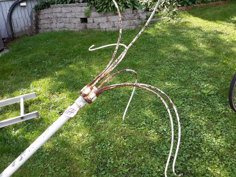 lot 174 image: Steel plant hanger.. Has Cement on base.. Needs some paint but would be a great addition for adding hanging plants to your yard or garden.