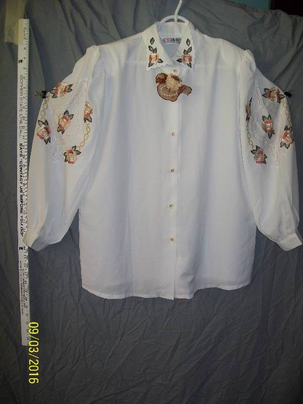 lot 19 image: Adult CostumeWhite-ish ShirtBlouse with Flower Design & Pin near neck. Unknown Size. TagHWA SHAN
