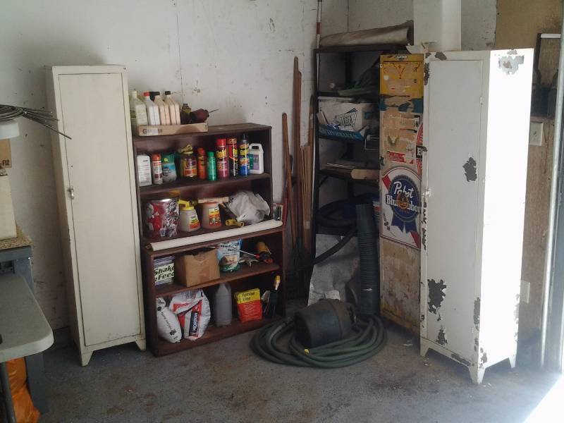 lot 7 image: Contents In Corner Of Garage 3-Vintage Single Door Metal Cabinets, Wood Shelf, Garden Supplies