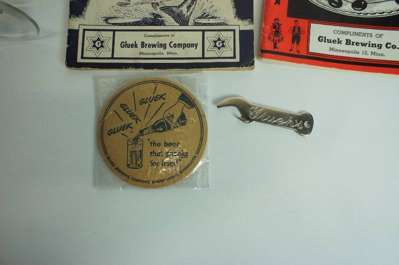 lot 76 image: Gluek beer group cookbook, sandwich book, bottle opener, coaster & 100 year anniversary glass