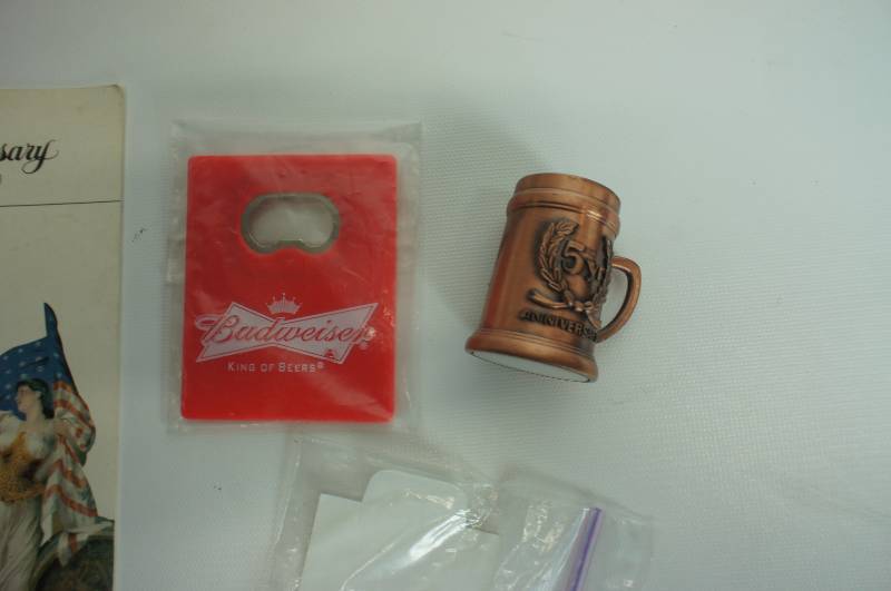 lot 77 image: Budweiser group cookbook, 100 year anniversary booklet, mini stein, bottle openers & golf tees