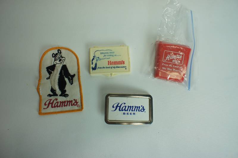 lot 64 image: Hamms beer group belt buckle sewing kit, bear patch, pen holder