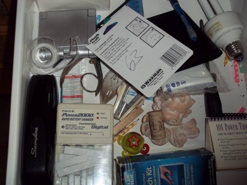 Contents of drawer including battery charger, light bulbs