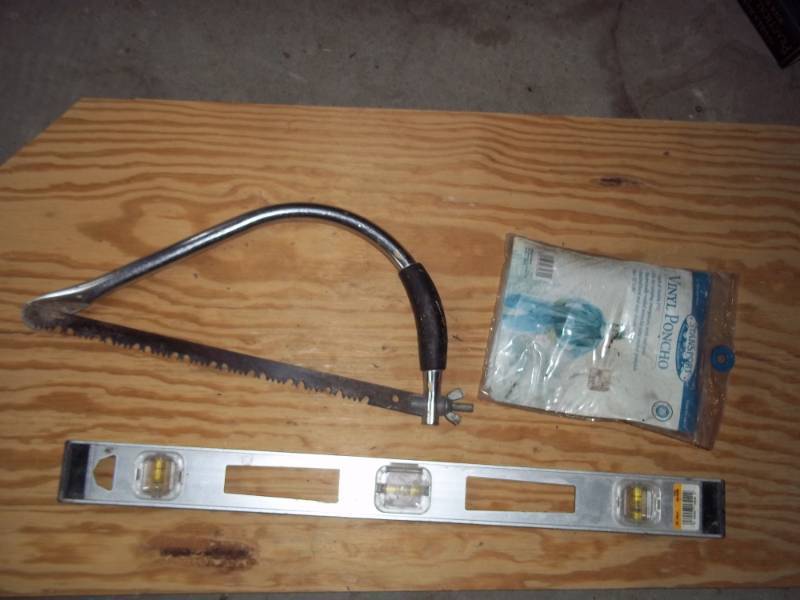 Level, bow saw and raingear