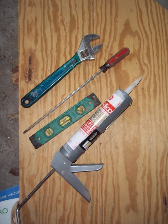 Cresent wrench, level, caulking gun and screwdriver