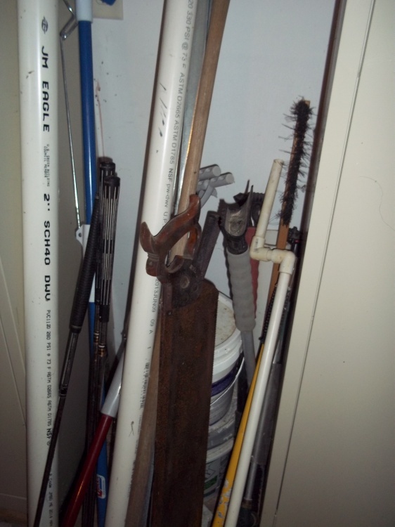 Saw, pvc pipe mop, and golf clubs