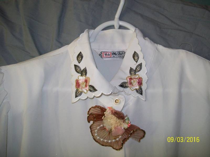 lot 19 image: Adult CostumeWhite-ish ShirtBlouse with Flower design & Flower Pin near neck.