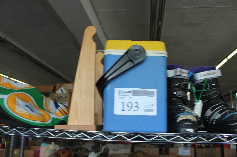 Ski boots, wooden ski rack, and a cooler
