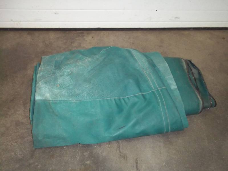 Green wood pile tarp may have rips